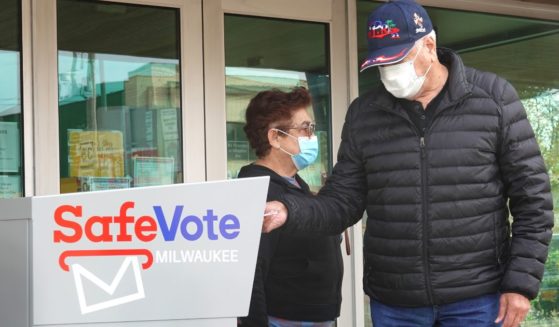 Residents drop mail-in ballots in an official ballot box outside of the Tippecanoe branch library in Milwaukee, Wisconsin, on Oct. 20, 2020.