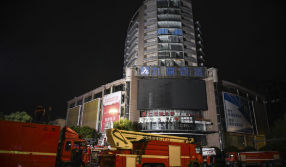 Fire engines are parked near a department store in Zigong City, southwest China's Sichuan Province on Thursday, following Wednesday's deadly fire at the department store.