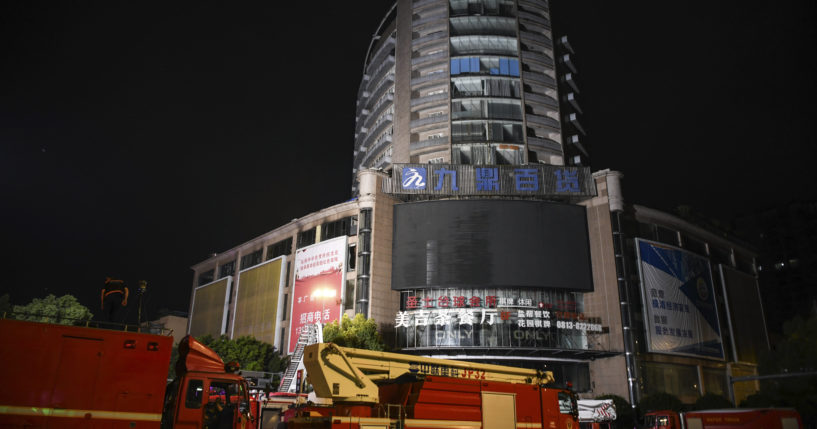 Fire engines are parked near a department store in Zigong City, southwest China's Sichuan Province on Thursday, following Wednesday's deadly fire at the department store.