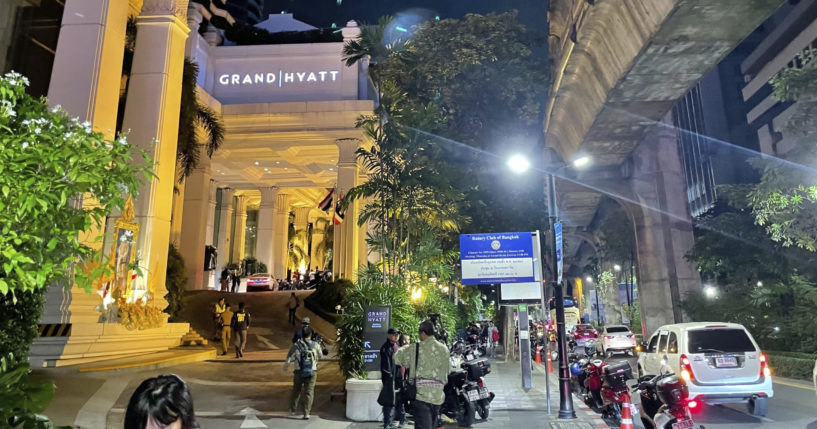 People walk outside a hotel where a number of people were found dead in Bangkok on Tuesday.