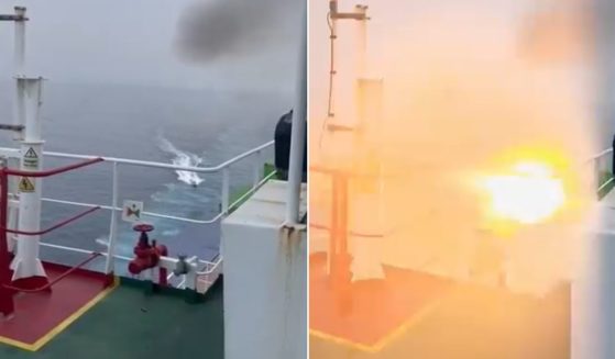 A boat approaches a cargo vessel and then explodes.