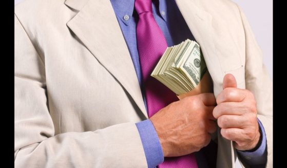 This Getty stock image shows a man suspiciously pocketing a large wad of cash.