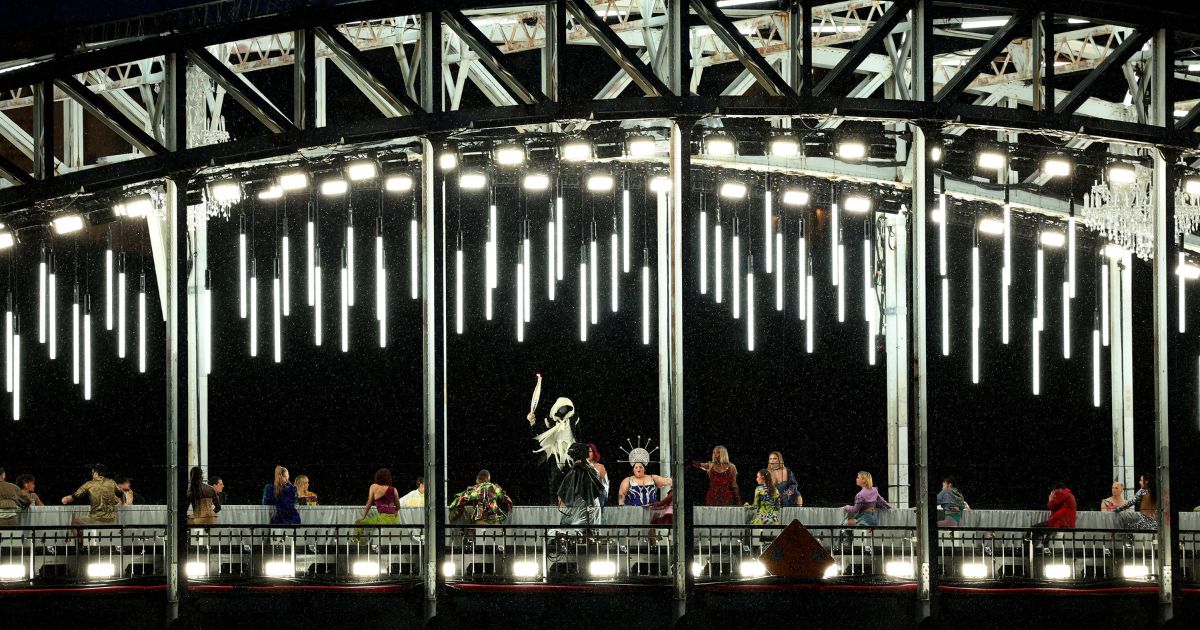 Mysterious Torchbearer holds the Olympic Torch while on a bridge during the opening ceremony of the Olympic Games Paris 2024 on July 26, 2024 in Paris, France.