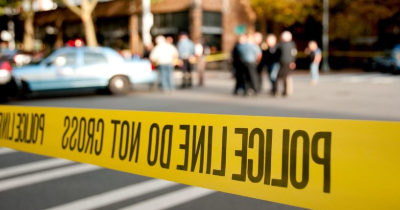 This Getty stock image shows a police scene, with yellow police tape in the foreground.