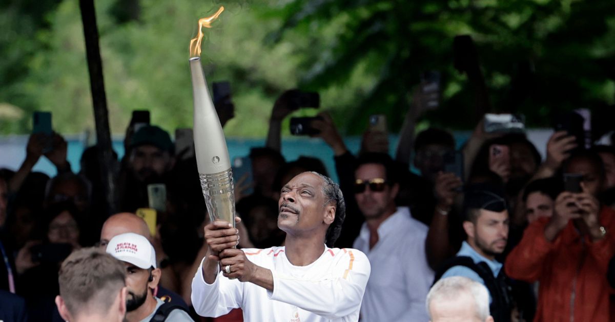 U.S. rapper Snoop Dogg holds the torch as part of the 2024 Paris Olympic Games Torch Relay, in Saint-Denis on July 26 in Paris, France.