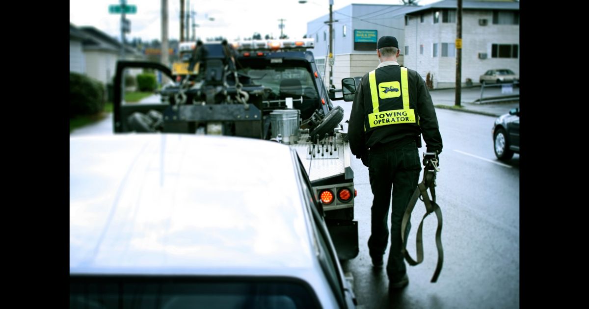 This Getty stock image shows a tow truck driver towing a vehicle.