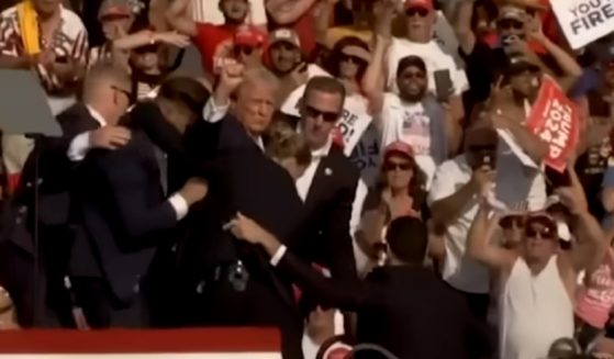 Formner President Donald Trump is escorted from Saturday's rally by Secret Service agents.