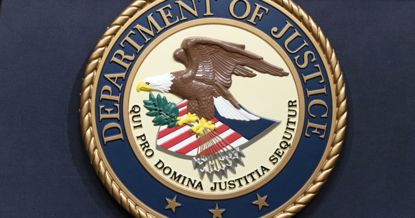 The Department of Justice seals is seen during a news conference at the DOJ office in Washington, May 16, 2023.