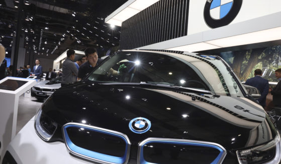 A worker cleans an electric vehicle at the BMW booth during the Auto Shanghai 2019 show in Shanghai on April 17, 2019.