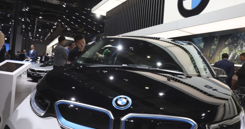 A worker cleans an electric vehicle at the BMW booth during the Auto Shanghai 2019 show in Shanghai on April 17, 2019.