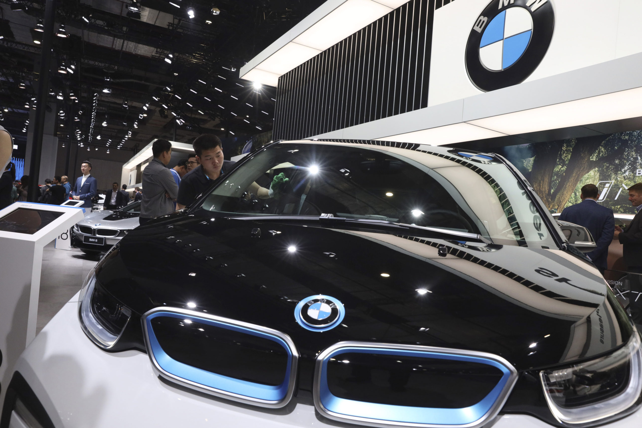 A worker cleans an electric vehicle at the BMW booth during the Auto Shanghai 2019 show in Shanghai on April 17, 2019.