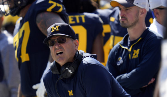 Michigan head coach Jim Harbaugh, front left, watches against Rutgers as analytics assistant Connor Stalions, right, looks on during an NCAA college football game in Ann Arbor, Michigan, September 23, 2023. Stalions is set to share his side of the story from an alleged sign-stealing scheme within Michigan’s football team before it went on to win the national championship.