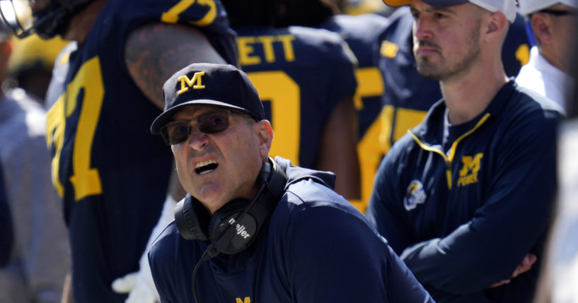 Michigan head coach Jim Harbaugh, front left, watches against Rutgers as analytics assistant Connor Stalions, right, looks on during an NCAA college football game in Ann Arbor, Michigan, September 23, 2023. Stalions is set to share his side of the story from an alleged sign-stealing scheme within Michigan’s football team before it went on to win the national championship.