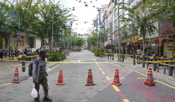 A man crosses a closed roadside after another deep sinkhole appeared a week after a woman fell into a sinkhole when a sidewalk caved in in Kuala Lumpur, Thursday, August 29, 2024.