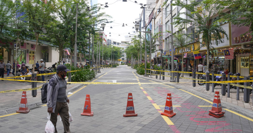 A man crosses a closed roadside after another deep sinkhole appeared a week after a woman fell into a sinkhole when a sidewalk caved in in Kuala Lumpur, Thursday, August 29, 2024.