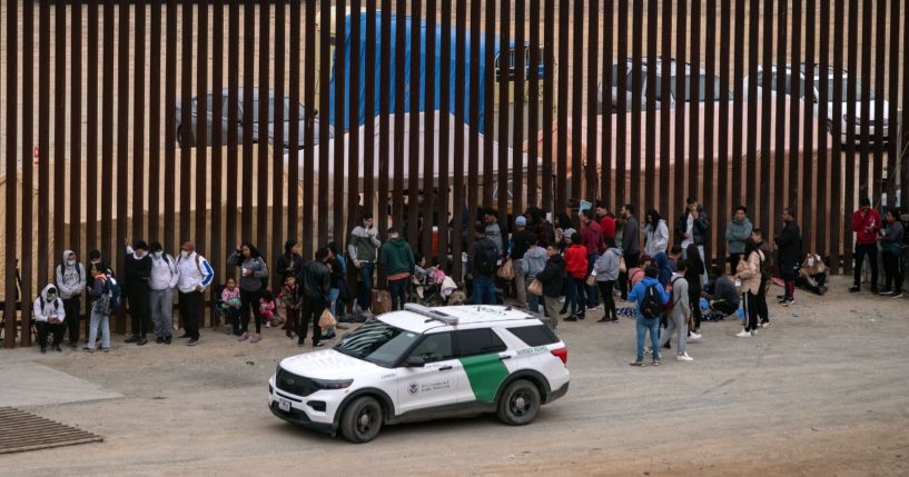 Illegal immigrants wait to be processed by the Border Patrol between fences at the US-Mexico border seen from Tijuana, Mexico, on June 5.