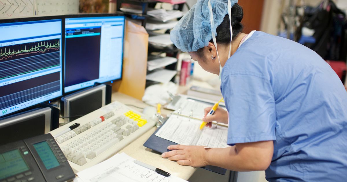 This stock image shows a nurse preparing medical paperwork in a hospital.