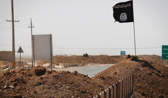 A flag of the Islamic State is seen on the other side of a bridge at the frontline of fighting between Kurdish Peshmerga fighters and Islamist militants in Rashad, Iraq, on Sept. 11, 2014.