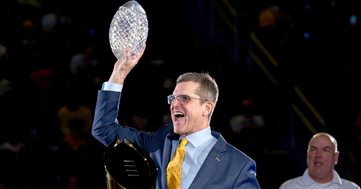 Then-head coach Jim Harbaugh of the Michigan Wolverines celebrates with the Coaches' Trophy during the Michigan Wolverines football National Championship celebration in Ann Arbor, Michigan, Jan. 13.