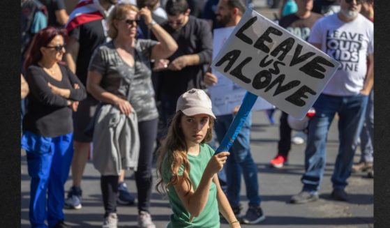 A girl holds a sign reading "Leave Us Alone" among anti-LGBTQ+ demonstrators outside a Glendale Unified School District Board of Education meeting in June of 2023 in Glendale, California.