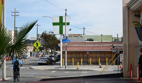 A sign with a green cross is seen outside an unlicensed cannabis dispensary in East Los Angeles, California, on Dec. 16, 2022.