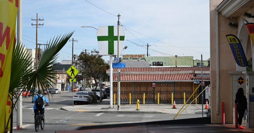 A sign with a green cross is seen outside an unlicensed cannabis dispensary in East Los Angeles, California, on Dec. 16, 2022.