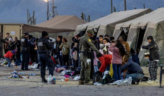 U.S. Customs and Border Protection agents instruct immigrants on separating important personal items from items to be discarded at a field processing center near the U.S.-Mexico border.