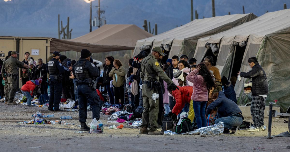 U.S. Customs and Border Protection agents instruct immigrants on separating important personal items from items to be discarded at a field processing center near the U.S.-Mexico border.