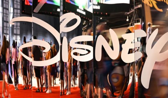 Attendees are reflected in Disney+ logo during the Walt Disney D23 Expo in Anaheim, California on September 9, 2022