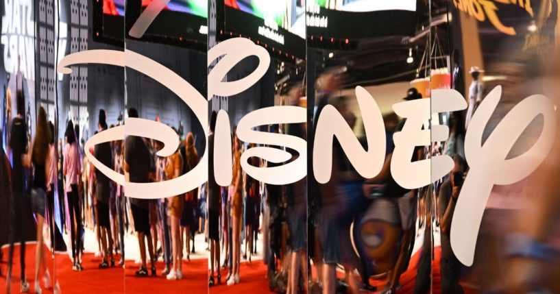 Attendees are reflected in Disney+ logo during the Walt Disney D23 Expo in Anaheim, California on September 9, 2022