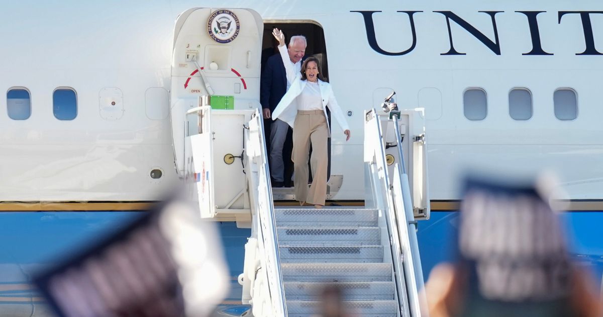 Democratic U.S. presidential candidate Vice President Kamala Harris and Democratic vice presidential candidate Minnesota Gov. Tim Walz walk off an aircraft after they landed at the Detroit Metropolitan Wayne County Airport for a campaign rally in Detroit, Michigan, on Aug. 7.