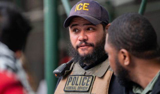 An ICE agent monitors hundreds of asylum seekers being processed upon entering the Jacob K. Javits Federal Building on June 6, 2023 in New York City. New York City has provided sanctuary to over 46,000 asylum seekers since 2013, when the city passed a law prohibiting city agencies from cooperating with federal immigration enforcement agencies unless there is a warrant for the person's arrest.