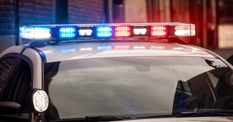 This stock image shows the light bar on a police cruiser flashing red and blue emergency lights.