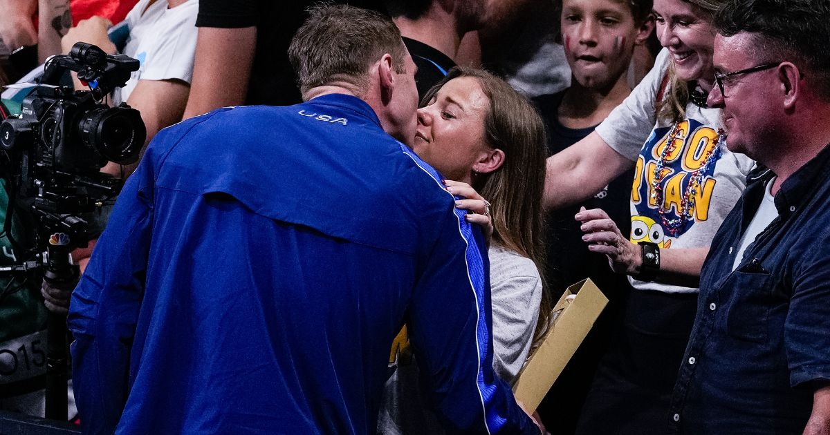 U.S. Olympic swimmer Ryan Murphy, left, kisses his wife, Bridget Konttinen, right, after winning the bronze medal in the men's 100-meter backstroke in the Paris Olympics in Nanterre, France, on Monday - and finding out he was going to be a girl dad.