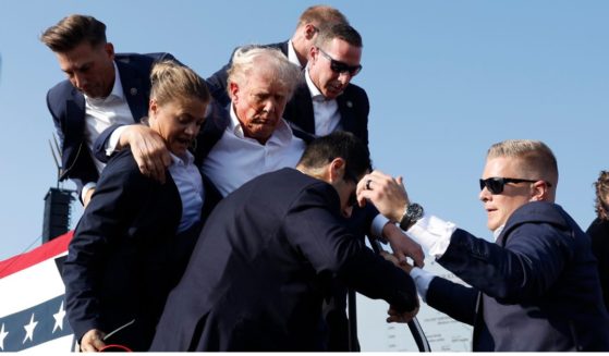 Former President Donald Trump, center, is surrounded by Secret Service agents after being shot by a would-be assassin at a campaign rally in Butler, Pennsylvania, on July 13.