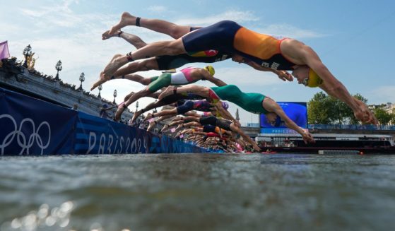 Athletes dive into the Seine river to start the swimming stage of the men's individual triathlon at the Paris 2024 Olympic Games on Wednesday.