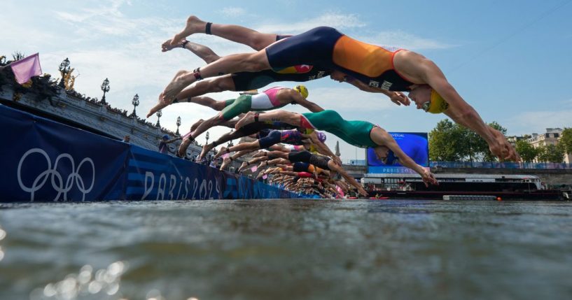 Athletes dive into the Seine river to start the swimming stage of the men's individual triathlon at the Paris 2024 Olympic Games on Wednesday.