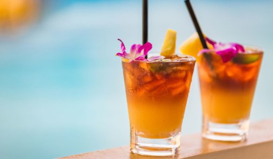 This stock image shows two drinks by a swimming pool at a hotel.