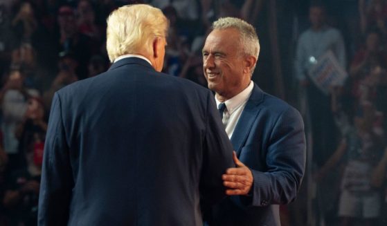 Robert F. Kennedy Jr. =, right, greets former President Donald Trump, left, onstage during a campaign rally at Desert Diamond Arena in Glendale, Arizona, on Friday.