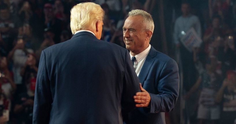 Robert F. Kennedy Jr. =, right, greets former President Donald Trump, left, onstage during a campaign rally at Desert Diamond Arena in Glendale, Arizona, on Friday.