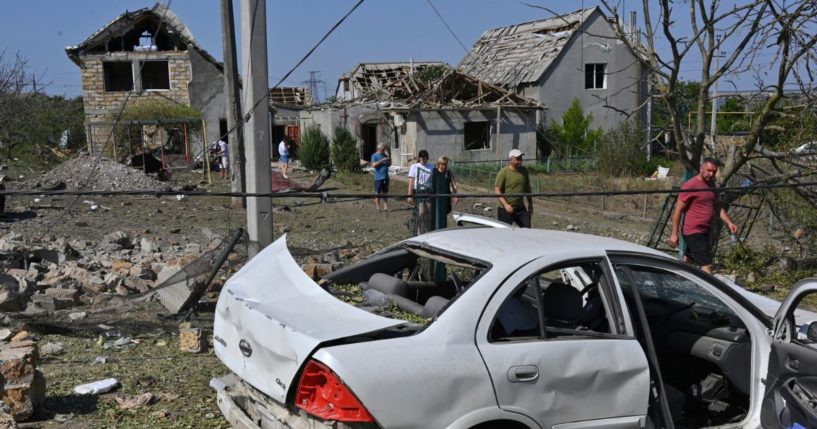 People walk in front of their damaged houses after the Russian rocket attack in Usatove village, Ukraine, on Monday.