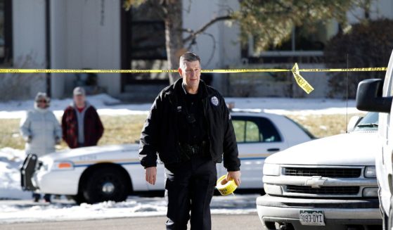 An Aurora, Colorado police officer carries crime scene tape to close off the street in front of a town home where four people were killed Saturday morning including the gunman who held police at bay for several hours at the complex January 5, 2013 in Aurora, Colorado. Aurora SWAT team members shot a gunman after he went to a second-floor window and fired at police. The gunman also allegedly fatally shot two men and a woman that he had taken hostage. One woman managed to escape from an upstairs back window, ran from the home and called police just before 3 a.m., said Cassidee Carlson, Aurora police spokeswoman.