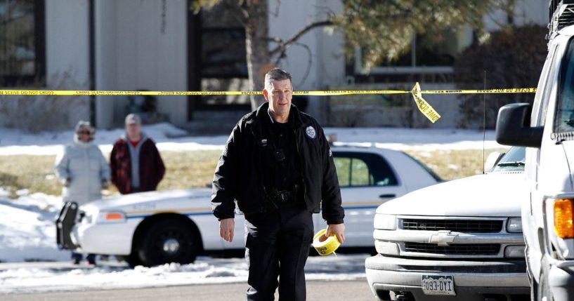 An Aurora, Colorado police officer carries crime scene tape to close off the street in front of a town home where four people were killed Saturday morning including the gunman who held police at bay for several hours at the complex January 5, 2013 in Aurora, Colorado. Aurora SWAT team members shot a gunman after he went to a second-floor window and fired at police. The gunman also allegedly fatally shot two men and a woman that he had taken hostage. One woman managed to escape from an upstairs back window, ran from the home and called police just before 3 a.m., said Cassidee Carlson, Aurora police spokeswoman.