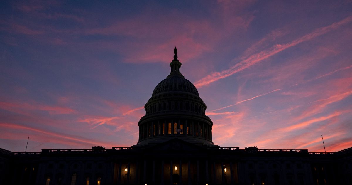 The sunset lights up the sky behind the U.S. Capitol Building as the region prepares for another summer heat wave on Sunday, in Washington, D.C.