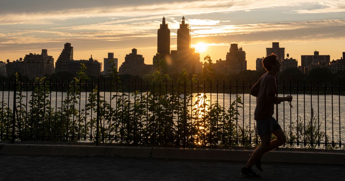 A person jogs in Central Park during sunset on July 25, in New York City.