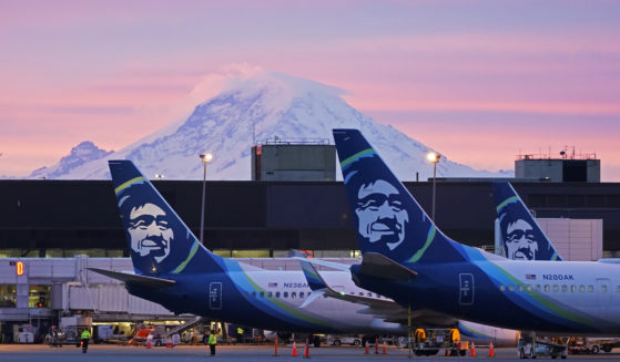 Alaska Airlines planes are shown parked at gates with Mount Rainier in the background at sunrise, March 1, 2021, at Seattle-Tacoma International Airport in Seattle.