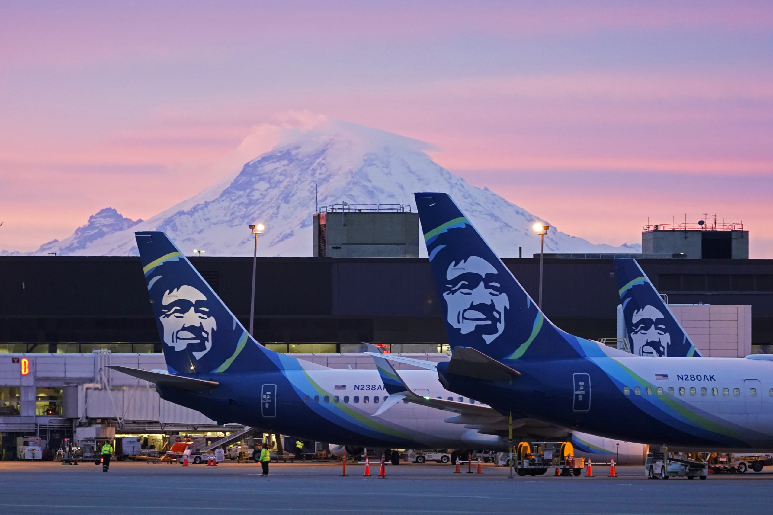 Alaska Airlines planes are shown parked at gates with Mount Rainier in the background at sunrise, March 1, 2021, at Seattle-Tacoma International Airport in Seattle.