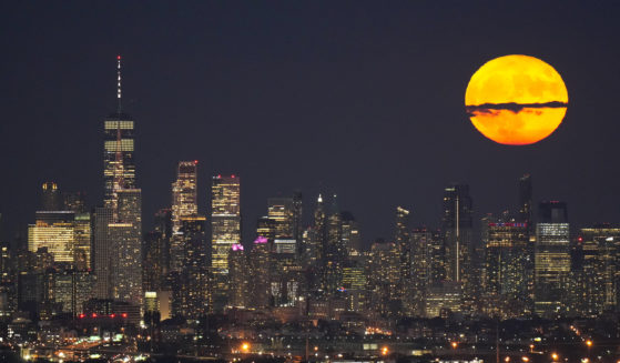 The moon rises through clouds over the skyline of lower Manhattan in this view from West Orange, New Jersey on Aug. 1, 2023, during a supermoon period.