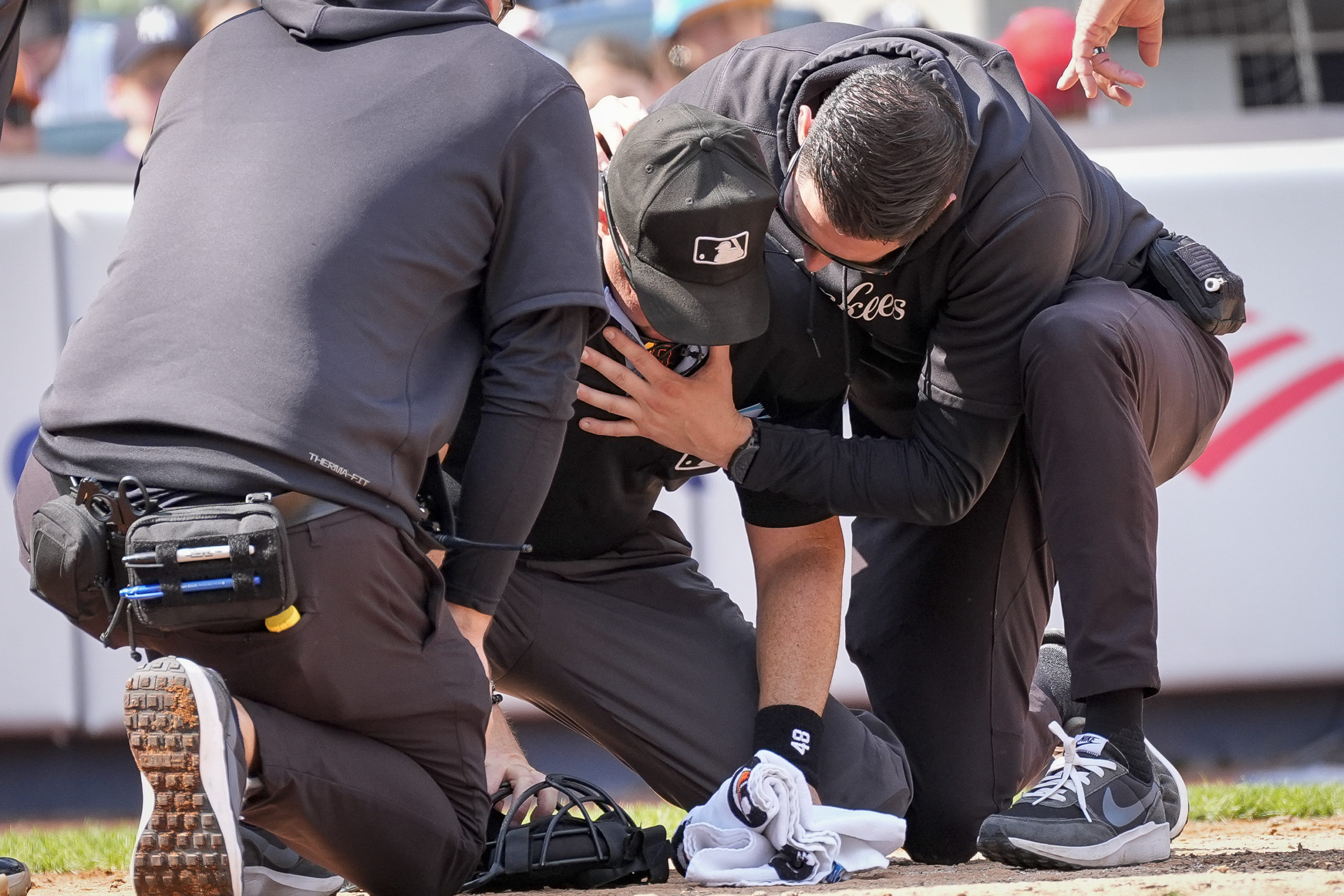 Medical staff tend to umpire Nick Mahrley, center, after he was hit by a bat during the fifth inning of a baseball game between the Colorado Rockies and the New York Yankees in New York on Sunday.