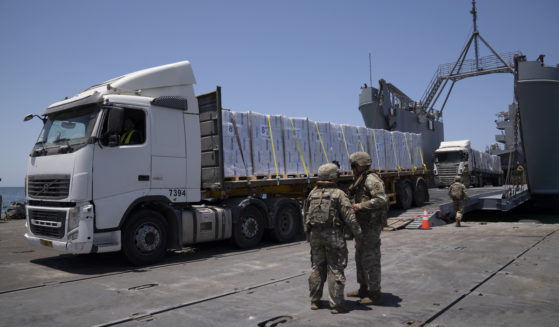 U.S. Army soldiers stand next to trucks arriving loaded with humanitarian aid at the U.S.-built floating pier Trident before reaching the beach on the coast of the Gaza Strip, June 25, 2024.